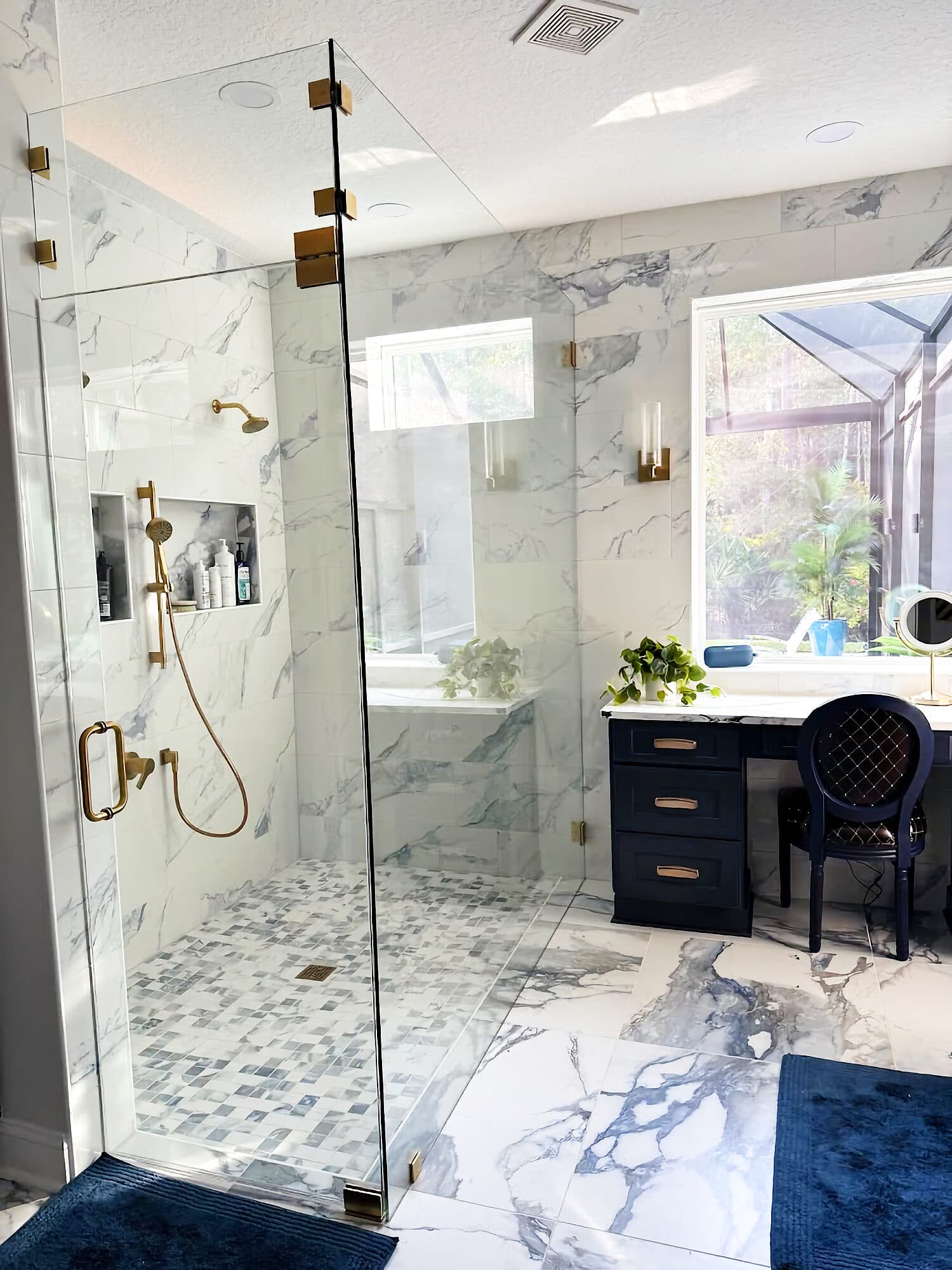 Marble walk-in shower with frameless glass and gold fixtures in a Coastal Oaks bathroom remodel, Nocatee, Florida
