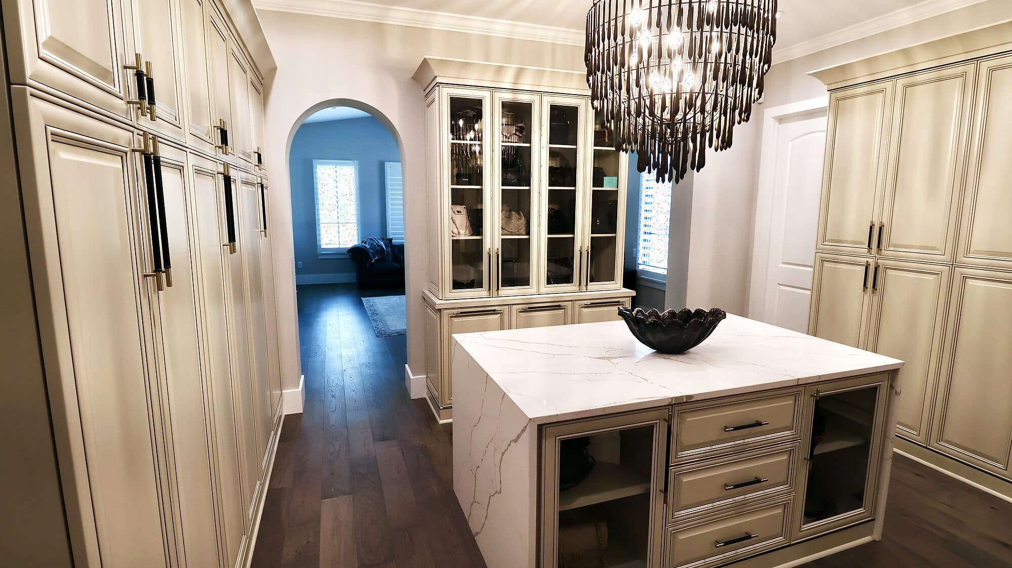 Custom walk-in closet with built-in cabinetry, drawers, and integrated lighting in a custom home in Nocatee, Florida