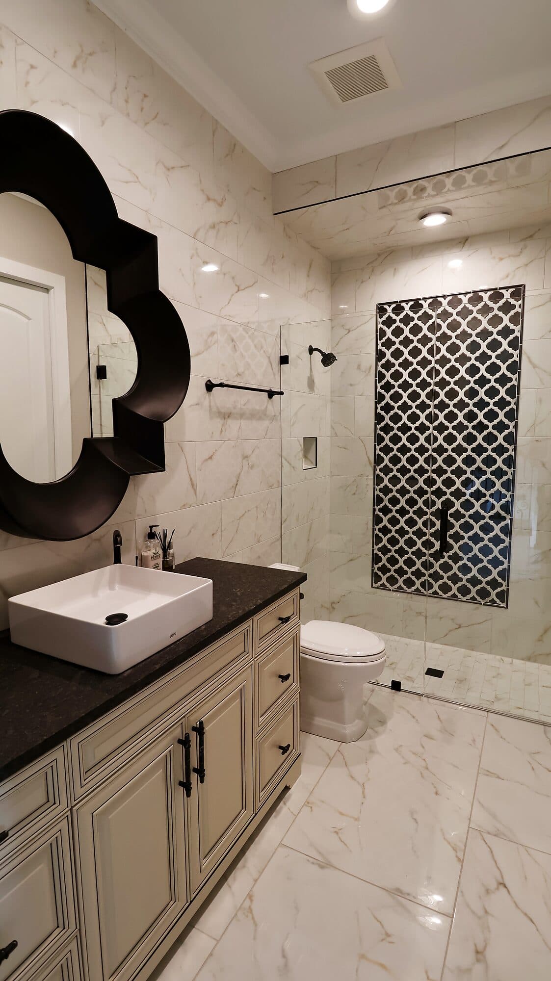 Master bathroom vanity with marble tile and a walk-in shower in a custom home in Nocatee, Florida