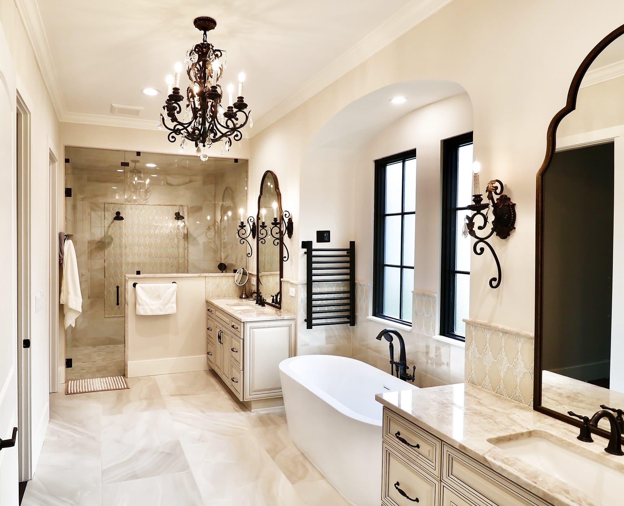 Master bathroom with a freestanding tub, chandelier, and marble tile in a custom home in Nocatee, Florida